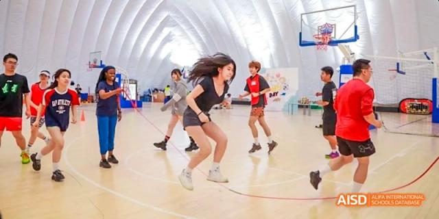 Students from JPED Academy, playing a game of basketball on a court.
