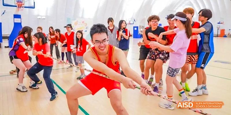 A male student from JPED Academy, pulling a rope during a tug-of-war game.