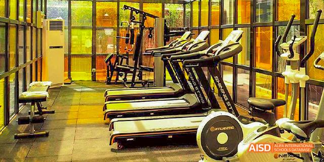 A wide view of a fitness center at JPED Academy, with treadmills and other exercise equipment.