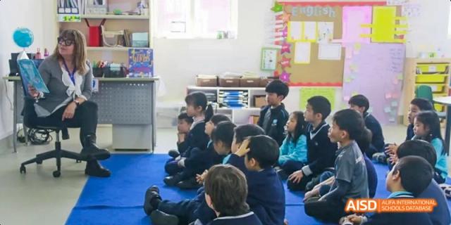 A group of young students sitting on the floor listening to a teacher, Léman International School Chengdu