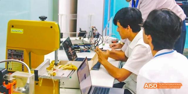 Two male students working on a project using laptops and electronic components, Léman International School Chengdu