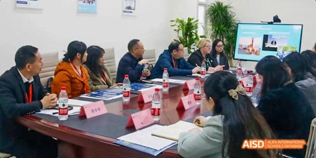 A group of adults seated at a long table during a meeting, Léman International School Chengdu