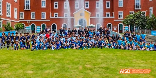 A large group of students and teachers posing for a photo on a grassy field, Léman International School Chengdu