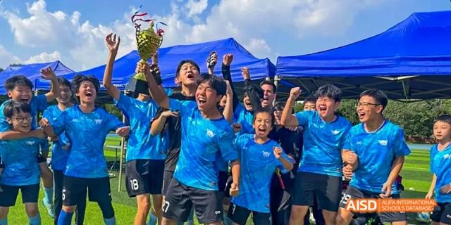 A group of students cheering enthusiastically at a sports event, Léman International School Chengdu