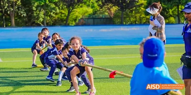 Students participating in a tug-of-war game on a grassy field, Léman International School Chengdu