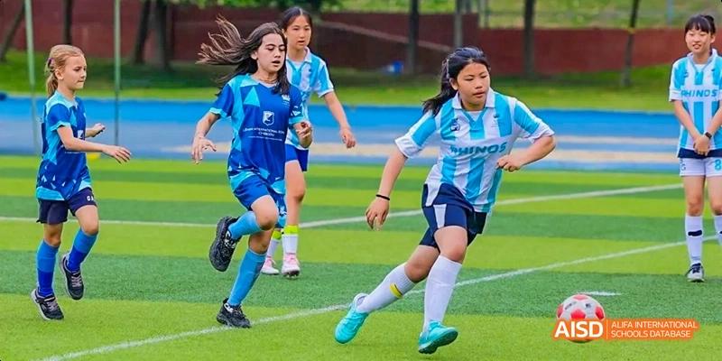 Two female students playing soccer on a field, Léman International School Chengdu