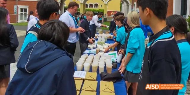 A group of people at a booth, preparing drinks and food for an event, Léman International School Chengdu