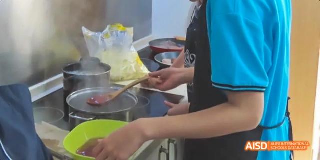 Students preparing and serving food at a school food stall, Léman International School Chengdu