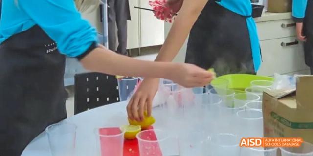 A student preparing a drink at a food booth, Léman International School Chengdu