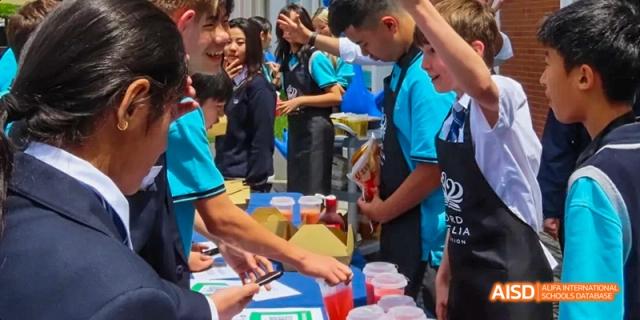 Students working together to serve food to a crowd at a school fair, Léman International School Chengdu