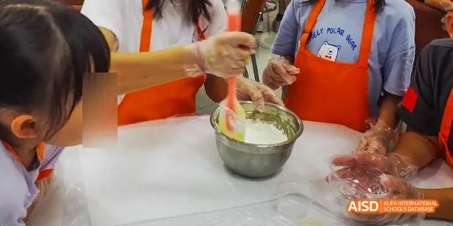 A student stirring a mixture in a large bowl, Léman International School Chengdu