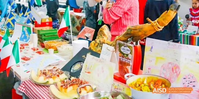 An assortment of international dishes and flags at a cultural food fair, Léman International School Chengdu