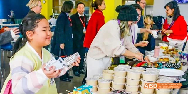 Students and teachers at a food booth, preparing and serving food, Léman International School Chengdu