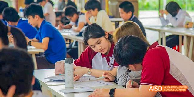 A student helping another during a collaborative class activity at Majestic International College.