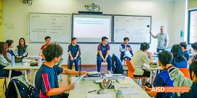 Two students giving a presentation to their classmates in a modern classroom at Majestic International College.