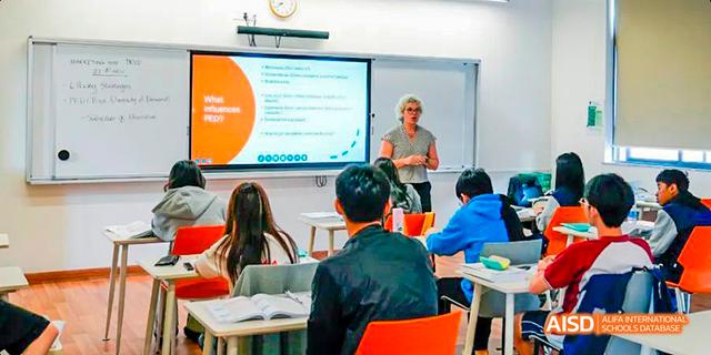 A teacher presenting a lesson with a digital projector to a class of students at Majestic International College.