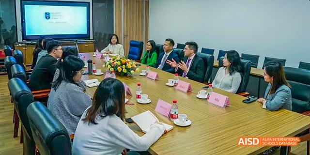 A group of school officials and guests seated around a table during a meeting at Majestic International College.