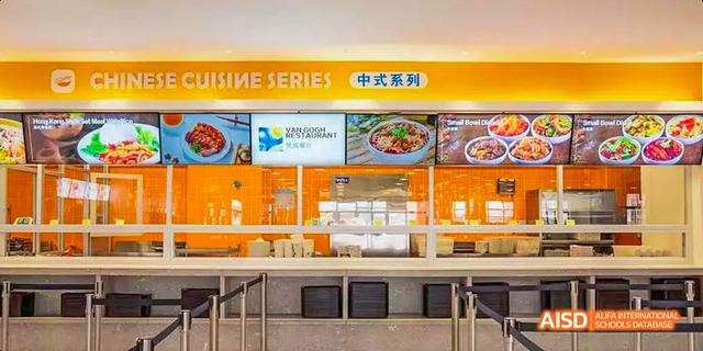 The interior of a modern school cafeteria with a yellow and orange color scheme and multiple food options at Majestic International College.