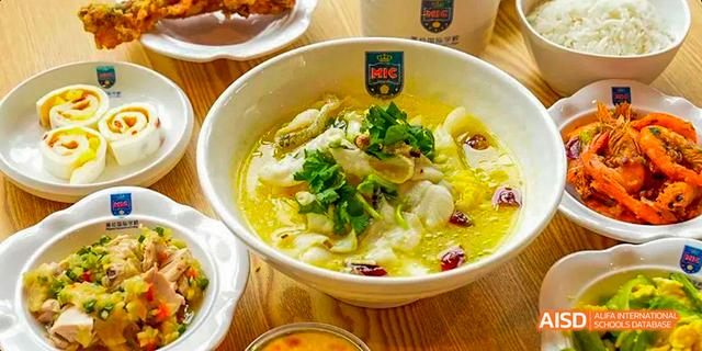 A large bowl of a fish dish with a logo on the bowl, served at Majestic International College.