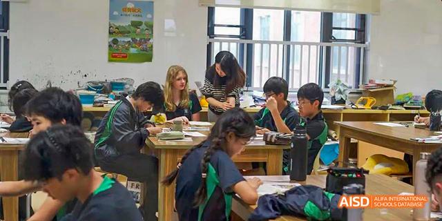A group of students are working together at a table in a classroom at Malvern College Chengdu.