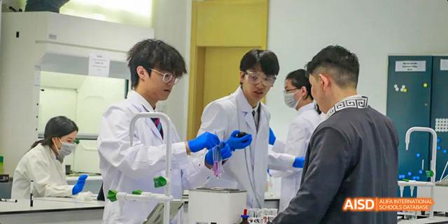 A group of male students in lab coats and blue gloves are working on a science experiment at Malvern College Chengdu.