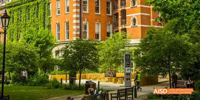 An outdoor shot of a brick building with trees and a courtyard at Malvern College Chengdu.