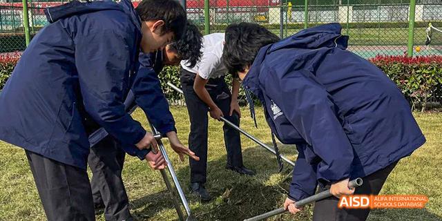 Students are working together to plant something outdoors at Malvern College Chengdu.