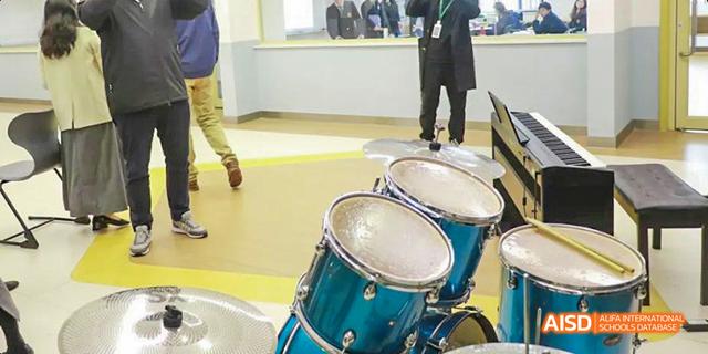 Two drum sets are set up on a stage at an event at Malvern College Chengdu.