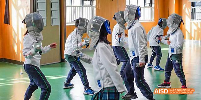 Students in protective gear are practicing fencing at Malvern College Chengdu.
