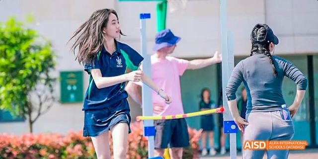 Two students are smiling at the camera during an outdoor event at Malvern College Chengdu.
