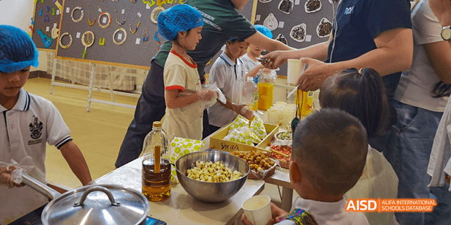 Students are serving themselves food from a large salad bar or buffet at Malvern College Chengdu.