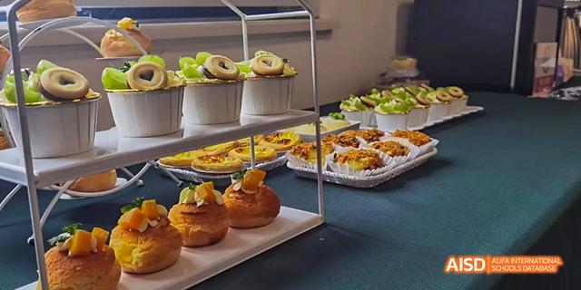 A buffet table is filled with various baked goods, including croissants and mini pizzas at Malvern College Chengdu.
