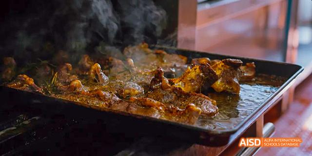A close-up shot of grilled ribs on a cooking surface at Malvern College Chengdu.