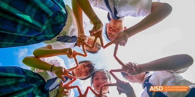 A group of students in red uniforms looking down at the camera at Maple Leaf International School - Luoyang.