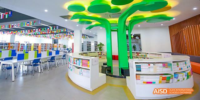 The interior of a school library with green tree-like columns at Maple Leaf International School - Luoyang.