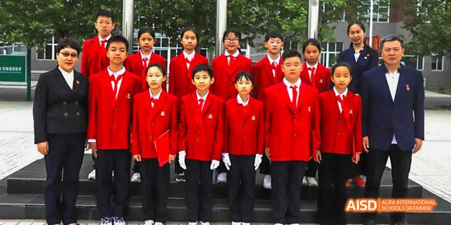 A group of students in red uniforms posing for a photo at Maple Leaf International School - Luoyang.