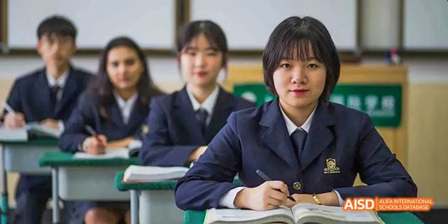 A close-up of two female students at their desks in a classroom at Maple Leaf International School - Luoyang.