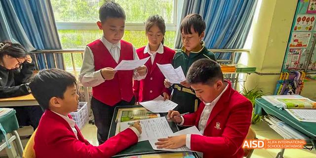 Students in red uniforms taking notes in a classroom at Maple Leaf International School - Luoyang.