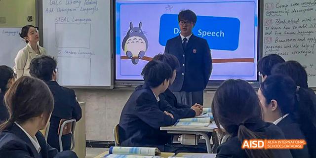 A student sitting at a desk with an open book at Maple Leaf International School - Luoyang.