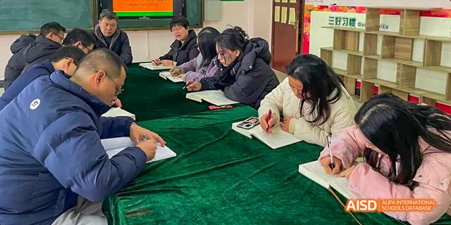 Students seated at a table and writing in a classroom at Maple Leaf International School - Luoyang.