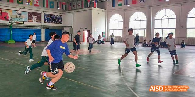 Students playing basketball indoors at Maple Leaf International School - Luoyang.
