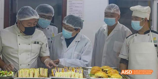 A person wearing a face mask and preparing food at Maple Leaf International School - Luoyang.