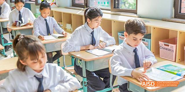 Two students from Maple Leaf International High School - Dalian are sitting at a desk and studying.