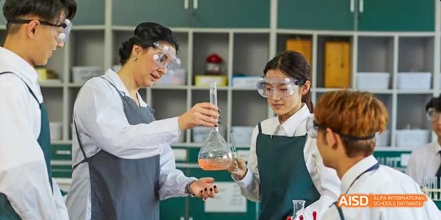 Two students from Maple Leaf International High School - Dalian performing a science experiment in a lab.