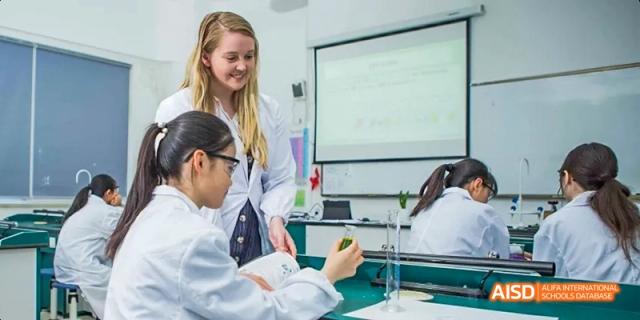 Students from Maple Leaf International High School - Dalian are looking at a computer screen in a lab.