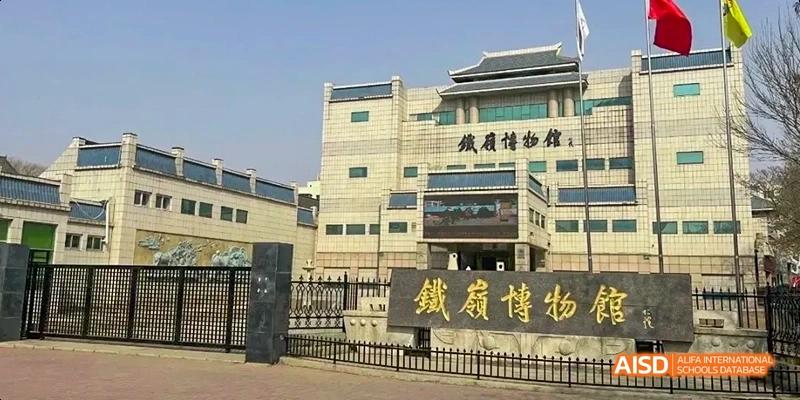 An exterior view of a school building with a sign that includes Chinese characters at Maple Leaf International High School - Dalian