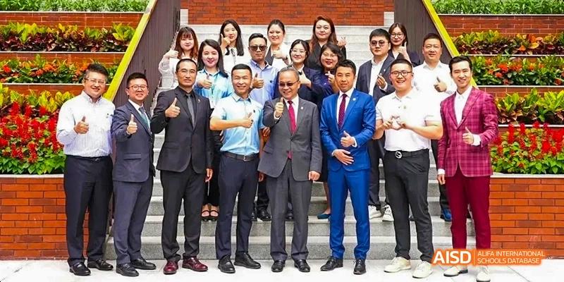 A group of men in suits posing for a photo at a school event at Maple Leaf International High School - Dalian