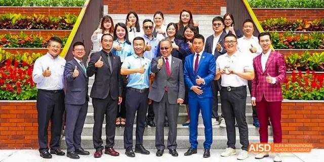A group of men in suits posing for a photo at a school event at Maple Leaf International High School - Dalian