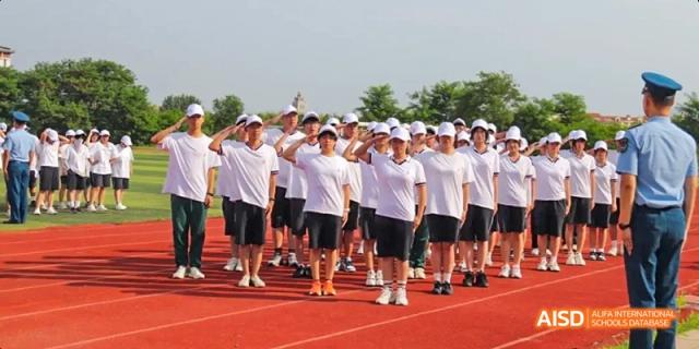 A group of students from Maple Leaf International High School - Dalian in white t-shirts standing together during a school activity.