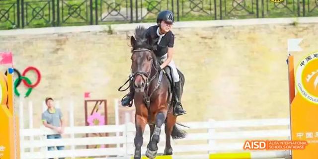 A student from Maple Leaf International High School - Dalian riding a horse during an equestrian event.